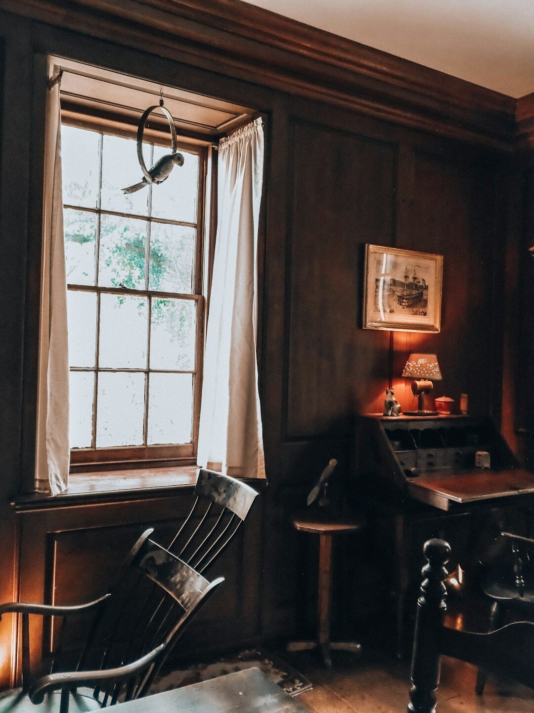 Croatian male writer sitting at a wooden desk at night writing with a typewriter and a lamp