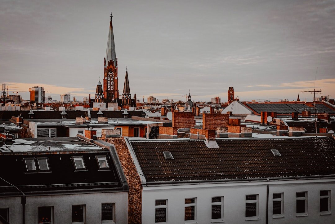 Book cover illustration of a cathedral spire above rooftops at dusk
