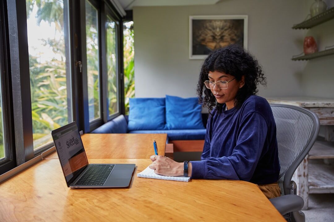 author writing at desk with notebook